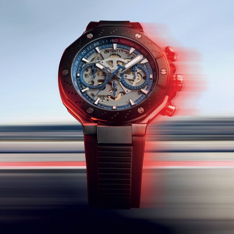 Tissot MotoGP 시계, 스켈레톤 다이얼, 파란색 크로노그래프 서브다이얼 및 타키미터 베젤이 장착된 동적이고 속도감 있는 배경.